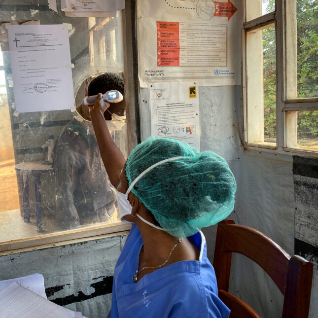 A medical worker checks a person's temperature at the Matanda Hospital in Butembo in the North Kivu province of Congo