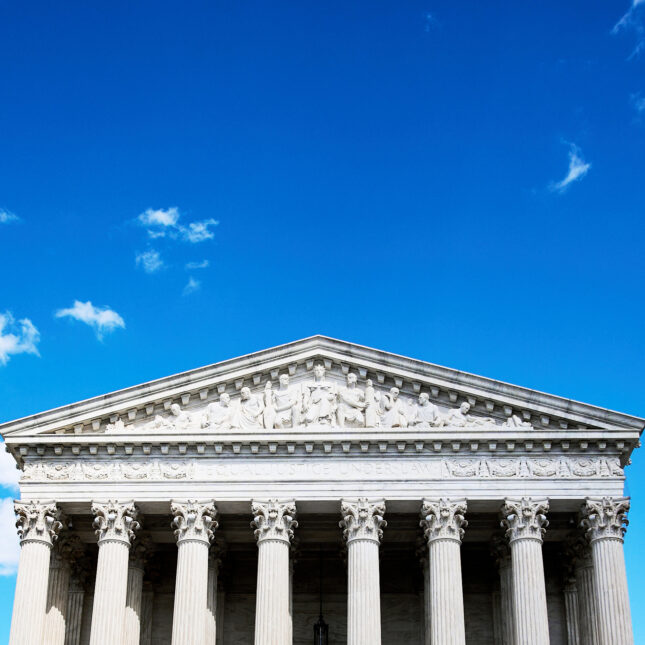 The Supreme Court is seen beneath a bright blue sky.