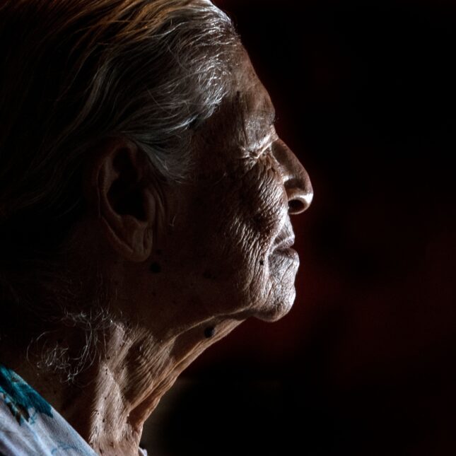 A file news photo of an elderly woman in profile against a dark background